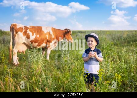 Kleiner Junge trinkt Joghurt im Freien Stockfoto