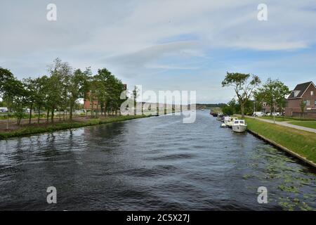 Boote, die an der Küste in der Nähe von Häusern in den Niederlanden festgemacht. Feder. Stockfoto