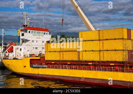 Dumaguete, Philippinen - 10. März 2020: Gelbes Frachtschiff im Hafen, mit beladenen Containern. Seeschifffahrt und Lieferservice. Güterverkehr trans Stockfoto