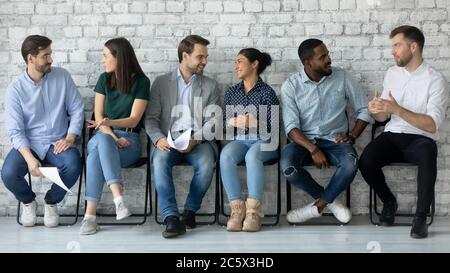 Gruppe von multiethnischen Menschen im Gespräch versammelt im Bürokorridor Stockfoto