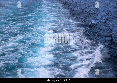 Meereswasser-Spritzwasser nach dem Motorboot. Blick auf die Seascape-Perspektive. Schiffstransport auf Kreuzfahrtschiff oder Motorboot. Weiße Welle auf ozeanischer Oberfläche. Dee Stockfoto