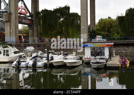 Boote und Paddelboote werden an einem Jachthafen in False Creek , False Creek, am Eingang zur Granville Island, unter der Granville Street, vertäut Stockfoto