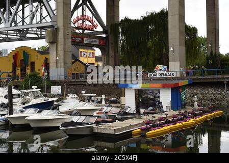 Boote und Paddelboote werden an einem Jachthafen in False Creek , False Creek, am Eingang zur Granville Island, unter der Granville Street, vertäut Stockfoto