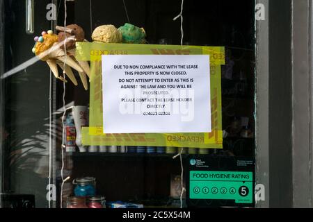 Ein Zeichen im Fenster eines Pachtladens, der für Nichteinhaltung des Mietvertrags wieder in Besitz genommen wurde. Stockfoto