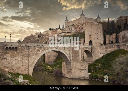 Toledo in Spanien mit dem Fluss Tejo und der römischen Brücke Puente de Alcantara. Berühmte UNESCO-Welterbestätte. Stockfoto