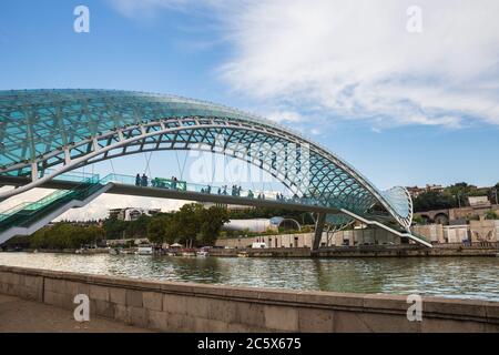 TIFLIS, GEORGIEN - 23. SEPTEMBER 2018: Menschen auf der Fußgängerbrücke des Friedens über den Fluss Kura Stockfoto