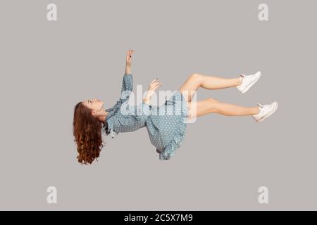 Schweben in der Luft. Entspannte Mädchen im Vintage Rüschen Kleid schweben Augen geschlossen halten, schlafen, während fliegen in der Luft, mit komfortablen friedlichen Traum Stockfoto