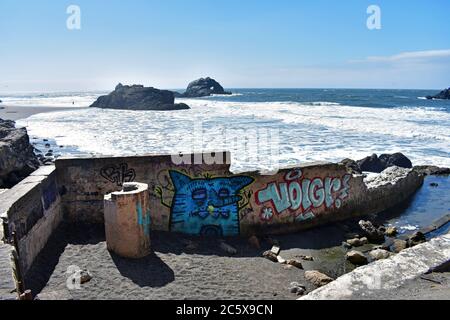 Die Ruinen von Sutro Baths in Lands End, San Francisco. Der Pazifik, Seal Rocks und blauer Himmel. Blaue Graffiti einer Katze wie Kreatur mit einer langen Nase. Stockfoto