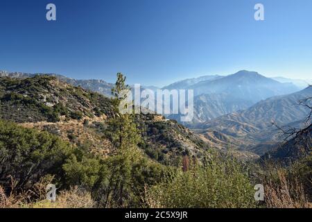 Der Blick vom Highway 180, der separate Teile des Kings Canyon National Park verbindet. Leichter Dunst über den Bergen und blauer Himmel. Kalifornien. Stockfoto