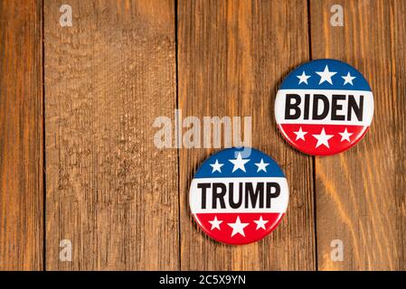 Washington DC - 5. Juli 2020; rot weiß und blau rund Trump und Biden 2020 Knöpfe des amerikanischen Präsidentschaftswahlkampfs sitzen nebeneinander auf Holztabl Stockfoto