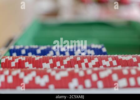 Ausgewählte Fokus auf Reihen von roten Kunststoff-Poker-Chips in der Poker-Box auf Holztisch und Defokussieren Hintergrund der blauen gesetzt. Stockfoto