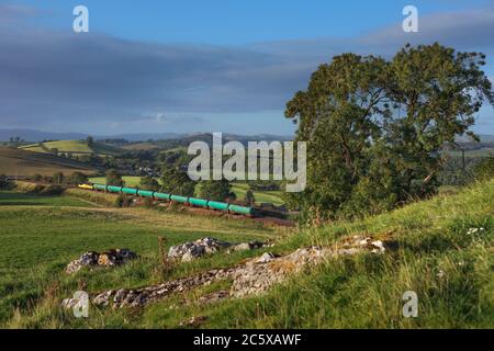 Colas Railfreight Lok der Baureihe 56 die Hauptlinie der Westküste mit einem Güterzug leerer Flugzeugtanks, der die Landschaft Cumbrias durchquert Stockfoto