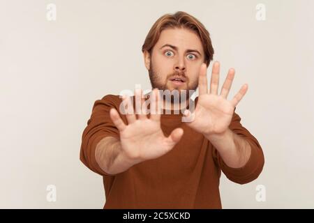 Nein, ich fürchte! Porträt von Panik erschreckt Mann mit Bart im Sweatshirt die Hände heben, um etwas erschreckend, schauend entsetzt, Phobie Co stoppen Stockfoto