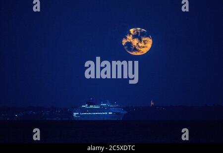 Isle of Wight. Juli 2020. Wetter in Großbritannien. Der Vollmond, bekannt als Buck Moon oder Thunder Moon, steigt hinter dem Kreuzfahrtschiff Oceana auf der Solent mit der Isle of Wight im Hintergrund auf. Credit Stuart Martin/Alamy Live News Stockfoto