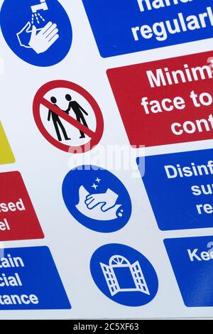 CV19, Covid-19 Schule Sicherheitsmassnahmen Warnschild & Warnpiktogramme am Tor der St. winnow Primary School, Lostwithiel. Piktogramm von Angesicht zu Angesicht Stockfoto