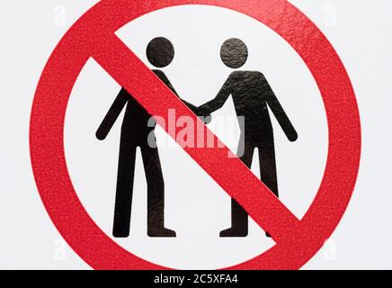 CV19, Covid-19 Schule Sicherheitsmassnahmen Warnschild & Warnpiktogramm. Am Tor der St. winnow Primary School, Lostwithiel. Piktogramm von Angesicht zu Angesicht Stockfoto