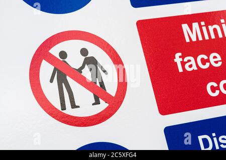CV19, Covid-19 Schule Sicherheitsmassnahmen Warnschild & Warnpiktogramm am Tor der St. winnow Primary School, Lostwithiel. Piktogramm von Angesicht zu Angesicht Stockfoto