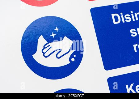 Covid-19 Schule Sicherheitsmassnahmen Warnschild & Warnpiktogramme. Am Tor der St. winnow Grundschule, Lostwihiel. Piktogramm Oberflächen desinfizieren Stockfoto