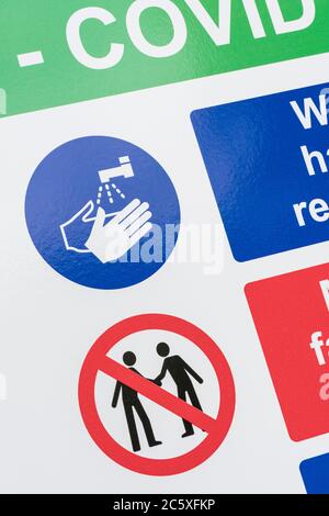 CV19, Covid-19 Schule Sicherheitsmaßnahmen Warnschild & Warnpiktogramme. Am Tor der St. winnow Primary School, Lostwithiel. Piktogramm Hände waschen Stockfoto