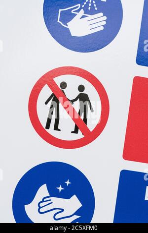 CV19, Covid-19 Schule Sicherheitsmassnahmen Warnschild & Warnpiktogramm am Tor der St. winnow Primary School, Lostwithiel. Piktogramm von Angesicht zu Angesicht Stockfoto