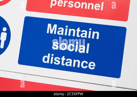 Covid-19 Schule Sicherheitsmassnahmen Warnschild & Warnpiktogramm am Tor der St. winnow Primary School, Lostwithiel. Sozialer Abstand Piktogramm Stockfoto