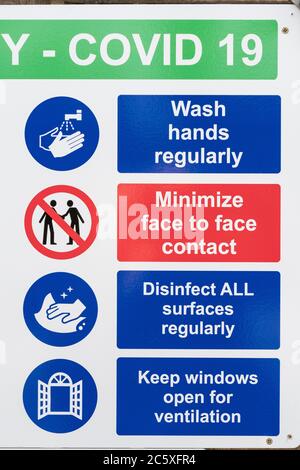 CV19, Covid-19 Schule Sicherheitsmaßnahmen Warnschilder & Warnpiktogramme. Am Tor der St. winnow Primary School, Lostwithiel. Piktogramm Hände waschen Stockfoto