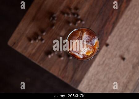 Hohes Glas kalten Brühkaffee auf einem hölzernen Couchtisch Stockfoto
