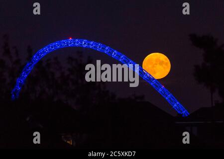 Wembley, Großbritannien. Juli 2020. UK Wetter - der Vollmond des Juli, bekannt als Buck Moon, erhebt sich hinter dem Wembley Stadium im Nordwesten Londons. Im Bauernalmanach ist der Buck Moon so benannt nach dem neuen Geweih, das um diese Jahreszeit aus der Stirn eines Bocks hervortritt. Der Bogen des Stadions ist blau beleuchtet, um den 72. Geburtstag des National Health Service (NHS) zu feiern und allen NHS-Mitarbeitern für ihre Bemühungen während der laufenden Coronavirus-Pandemie zu danken. Kredit: Stephen Chung / Alamy Live Nachrichten Stockfoto