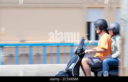 Belgrad, Serbien - 4. Juli 2020: Reifes Paar, das auf der Stadtstraßenbrücke auf dem Roller reitet, Nahaufnahme Stockfoto