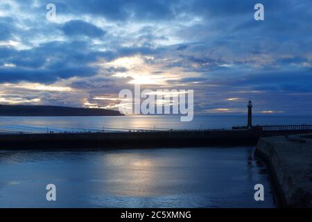 Die Sonne beginnt hinter einem wolkenlosen Himmel in Whitby, North Yorkshire untergehen Stockfoto