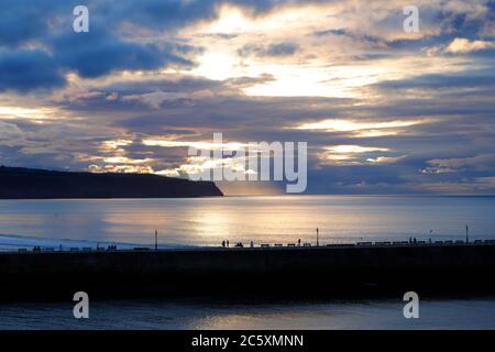 Die Sonne beginnt hinter einem wolkenlosen Himmel in Whitby, North Yorkshire untergehen Stockfoto