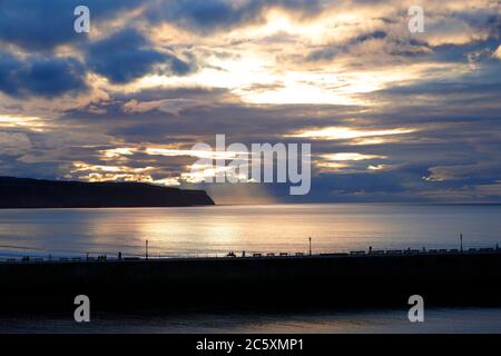 Die Sonne beginnt hinter einem wolkenlosen Himmel in Whitby, North Yorkshire untergehen Stockfoto