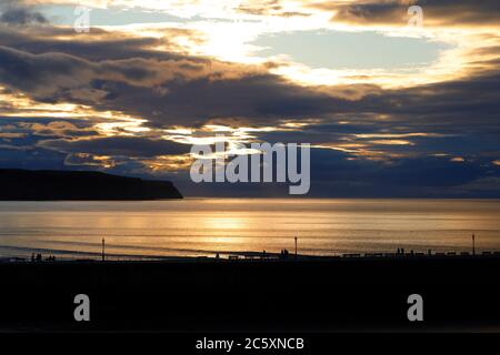 Die Sonne beginnt hinter einem wolkenlosen Himmel in Whitby, North Yorkshire untergehen Stockfoto