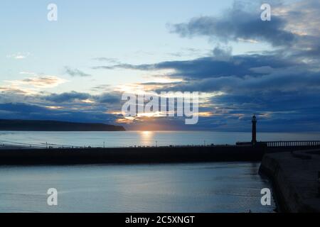 Die Sonne beginnt hinter einem wolkenlosen Himmel in Whitby, North Yorkshire untergehen Stockfoto