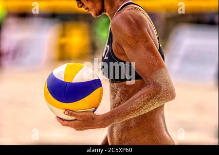 Eine weibliche Beach Volleyball-Spieler ist immer bereit, den Ball zu dienen Stockfoto