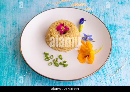 Quinoa-Teller-Präsentation mit essbaren Blumen dekoriert Stockfoto