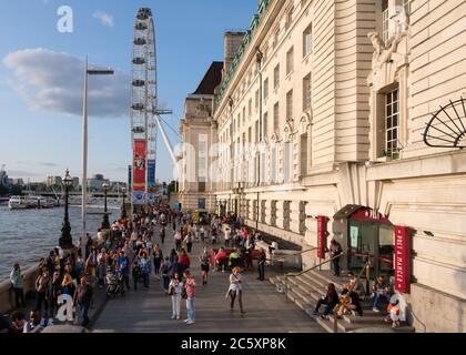 Menschen in der Southbank nahe dem London Eye bei Sonnenuntergang Stockfoto