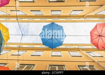 Bunte Regenschirme hängen über der alten Durchgangsstraße von Wien Österreich Stockfoto