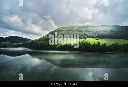 Herzform auf einem grünen Hügel, umgeben von Bergen, Bäumen, Fluss und einsamer, leerer Straße. Liebeszeichen in Erinnerung an einen verlorenen Angehörigen in Myczkowce, Polen. Stockfoto