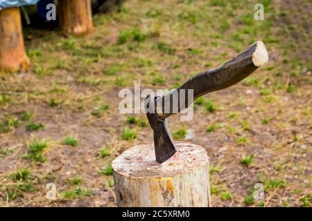 Camping im Freien - Zelte, Ausrüstung und Kochen. Camping im Sommer. Kochen Brennholz, eine Axt in einem Stumpf stecken. Stockfoto