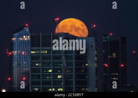 London, Großbritannien. Juli 2020. UK Wetter: Vollmond "Buck Moon" steigt über der Stadt vom Primrose Hill aus gesehen. Der „Buck Moon“ wird in Bezug auf die Zeit, in der das Geweih der männlichen Hirsche wächst, als „Buck Moon“ bezeichnet und ist seit langem mit Entspannung und Beobachtung der Zyklen der Natur verbunden. Kredit: Guy Corbishley/Alamy Live Nachrichten Stockfoto