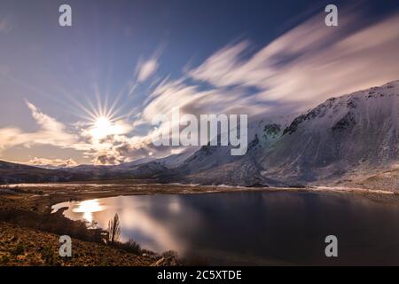 Landschaftsansicht gegen Sonne und schneebedeckte Anden in Willimanco Lagoon, Esquel, Patagonien, Argentinien Stockfoto