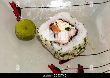 Das japanische Sushi-Essen ist ausgezeichnet. Maki und Brötchen mit Thunfisch, Lachs und Avocado. Draufsicht auf Sushi-Rolle. wasabi. Selektiver Fokus. Stockfoto