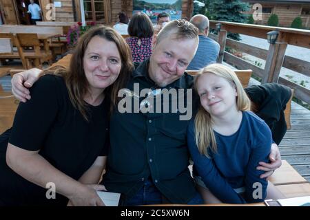 Fröhliche Familie posiert und lächelt im Restaurant Karczma Spalska im Freien. Spala Mittelpolen Stockfoto