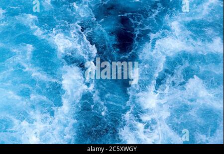 Schiffsweg auf dem Meerwasser Draufsicht Foto. Weißer Schaum auf blauem Wasser. Transport auf See. Tropical Island Hopping Konzept. Kreuzfahrt im Sommer. Wellig Stockfoto