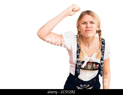 Junge schöne blonde Frau trägt oktoberfest Kleid wütend und verrückt Erhöhung Faust frustriert und wütend, während schreien mit Wut. Wut und Aggressiv Stockfoto