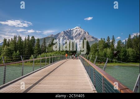 Banff, Alberta - 3. Juli 2020: Blick auf eine Fußgängerbrücke in Banff im Sommer. Banff ist die Hauptstadt im Banff Nationalpark und ein Zentrum von Touri Stockfoto