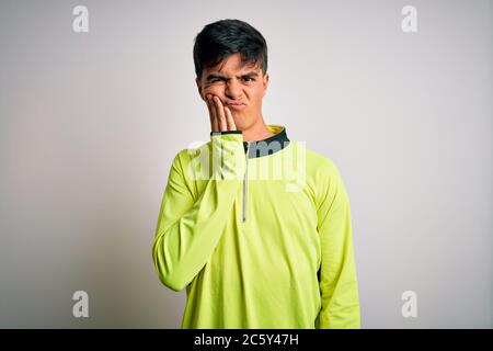 Junge gutaussehende Sportler tun Sport tragen Sportbekleidung über isolierten weißen Hintergrund berühren Mund mit Hand mit schmerzhaften Ausdruck wegen zu Stockfoto