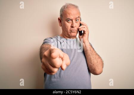 Mittelalter Hortmann mit Gespräch auf dem Smartphone sprechen über weißen Hintergrund zeigt mit dem Finger auf die Kamera und zu Ihnen, Hand Zeichen, POS Stockfoto