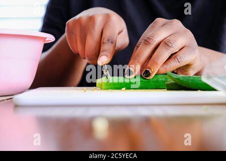 Frau, die den Nigerianer Okra Okra für die Aufbewahrung im Kühlschrank vorbereitet Stockfoto